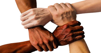 Vier Hände greifen ineinander