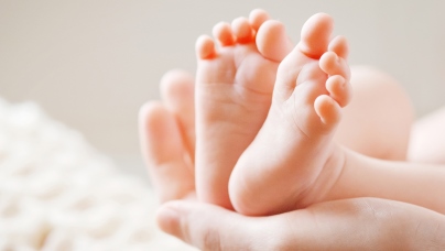 Babyfüße in den Händen der Mutter.